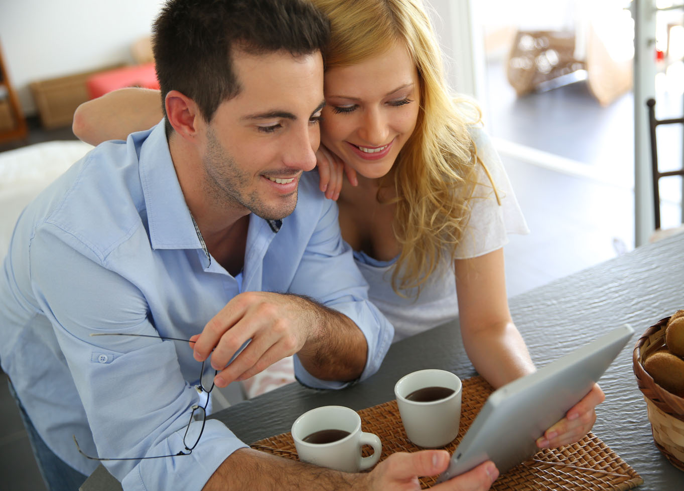 Mutlu bir kadın ve erkek tabletle online alışveriş yapıyor